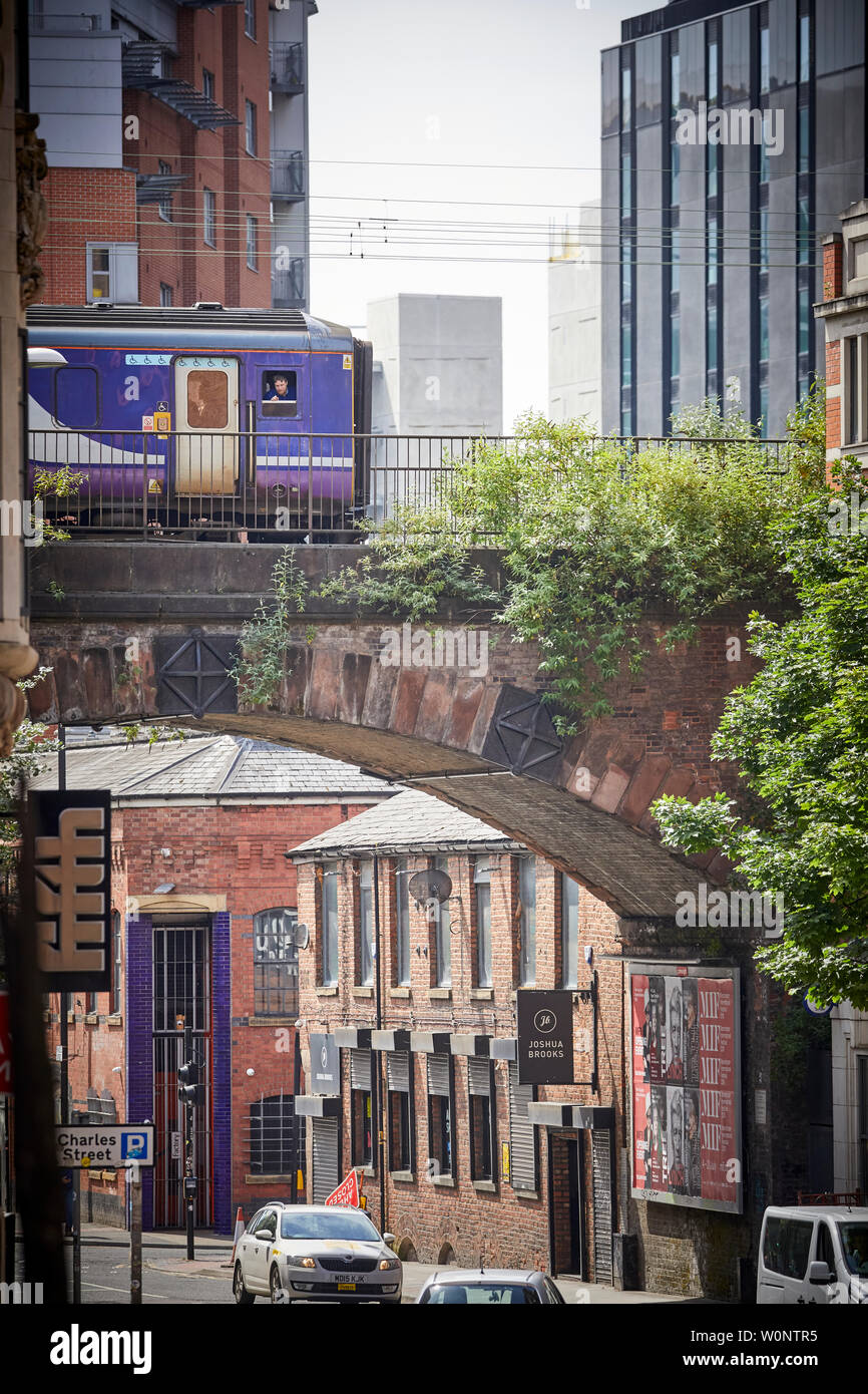 Il centro della città di Manchester, a nord del velocista treno passa Princess Street con Joshua Brooks pub dietro Foto Stock