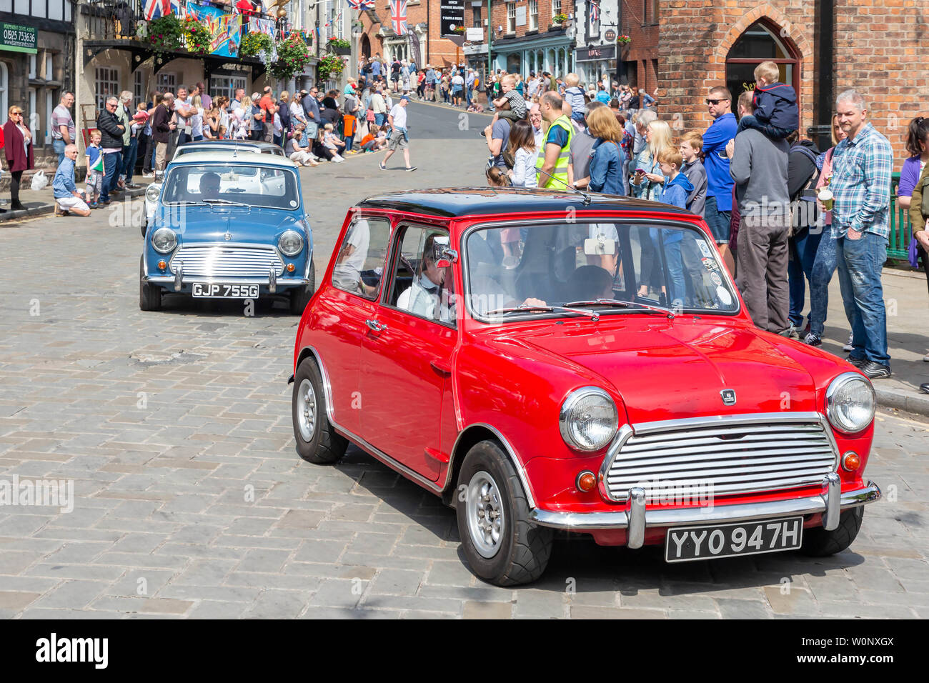Rosso, bianco e blu mini automobili simile a The Italian Job parade attraverso il villaggio di Lymm nel loro storico giorno di trasporto Foto Stock