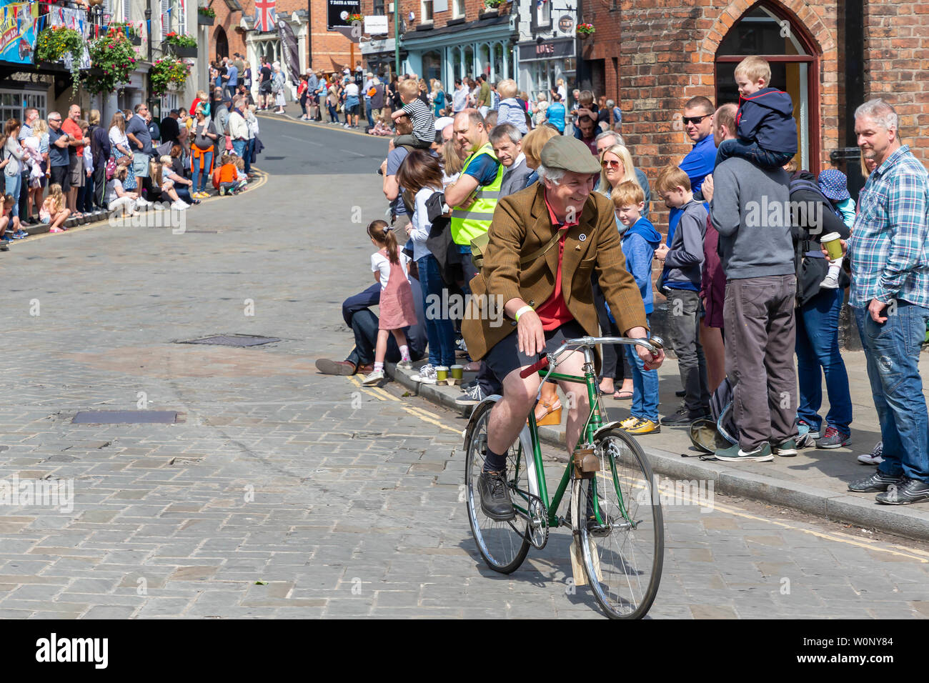 Un cavaliere solitario su un ciclo di antiquariato in Lymm trasporto storico sfilano per le vie del paese Foto Stock
