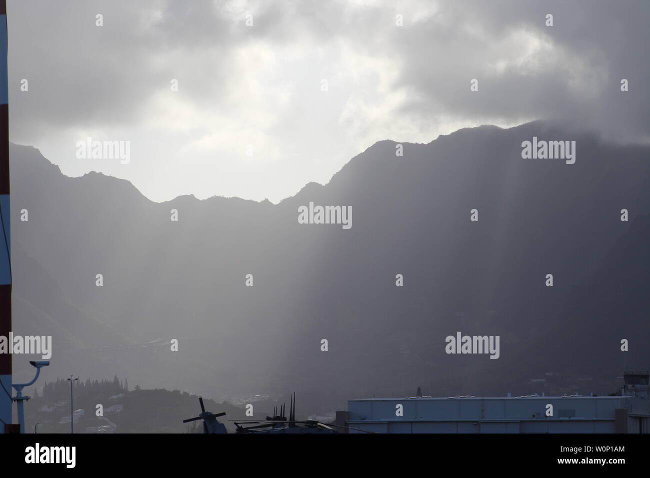 La luce del sole proveniente da sopra le montagne in Hawaii Kai, Hawaii sull'isola di Oahu. Essa appare come luce di Dio che risplende attraverso le nuvole. Foto Stock