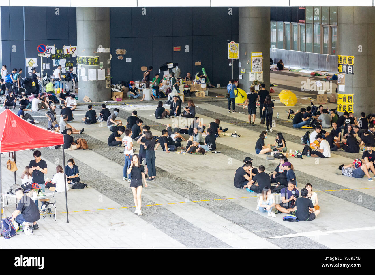 Hong Kong 2019 extradition bill protestare : manifestanti indossare nero e rilassatevi con gli amici al campo base nella parte anteriore del Governo di HK HQ Foto Stock