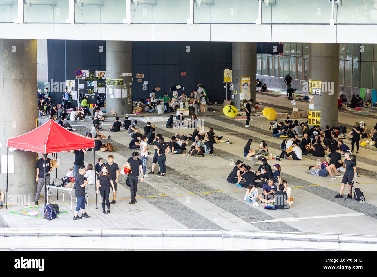 Hong Kong 2019 extradition bill protestare : manifestanti indossare nero e rilassatevi con gli amici al campo base nella parte anteriore del Governo di HK HQ Foto Stock