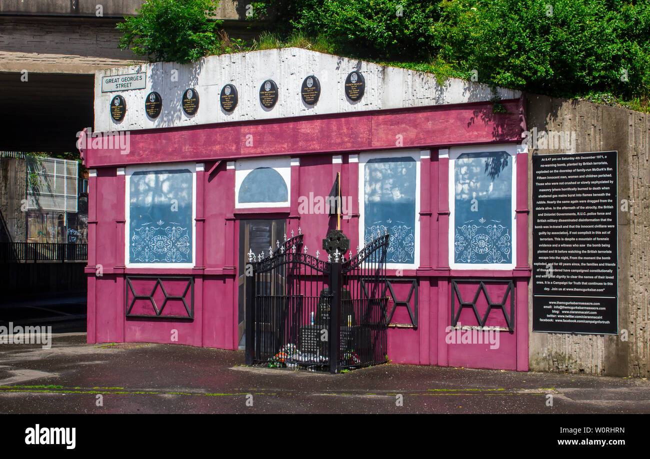 17 giugno 2019 il memoriale facciata e Celtic cross sul sito di McGurk's Bar dove quindici persone sono state assassinate in una bomba a orologeria atrocità perpetrate dalla UVF Foto Stock
