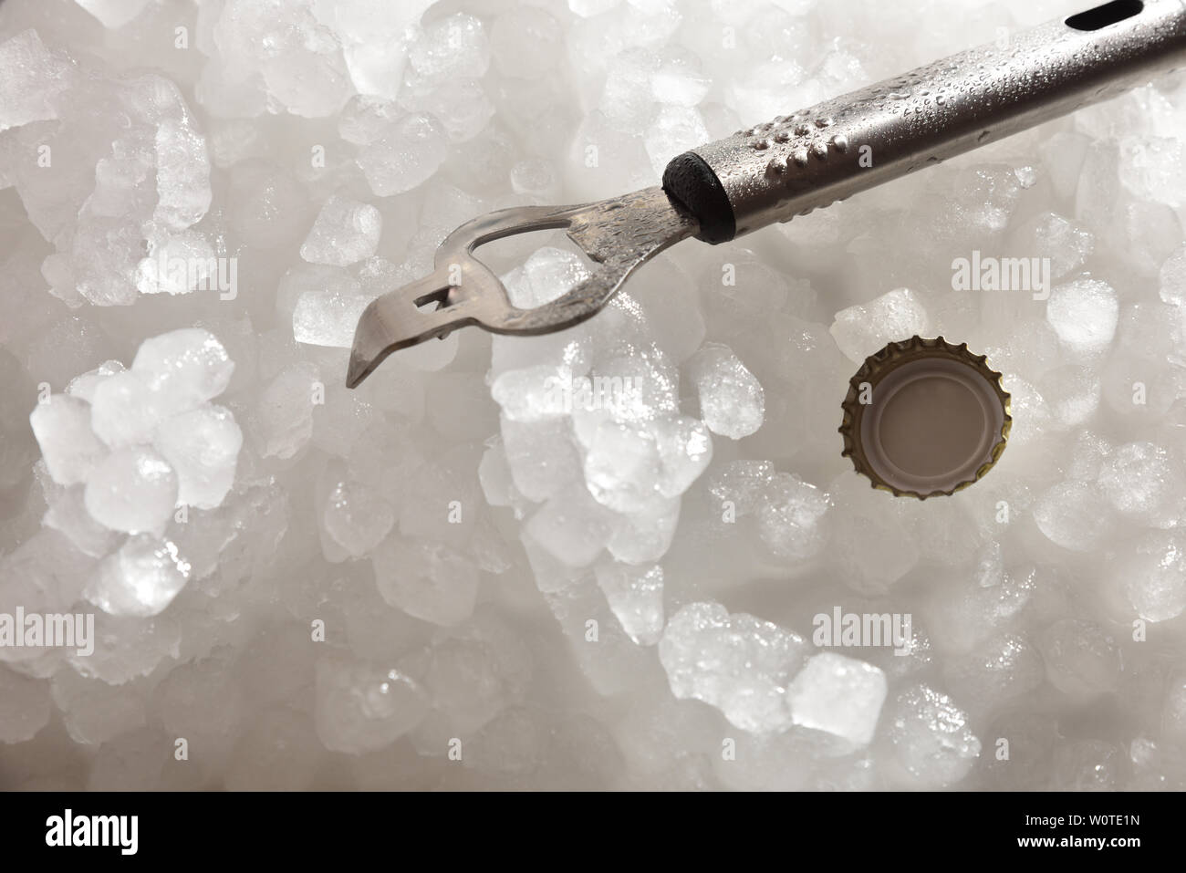 Apribottiglie e il tappo sul ghiaccio tritato close up . Composizione orizzontale. Top vista in elevazione. Foto Stock