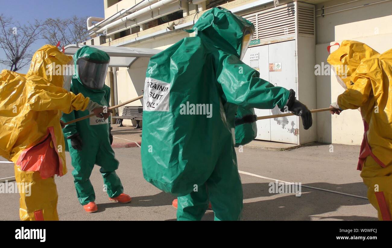 I vigili del fuoco di medicazione suite di protezione delle vittime di pulizia da perdite tossici dei gas medicali in ospedale Haemek durante il trapano. Afula, Israele, 30 Gennaio 2017 Foto Stock