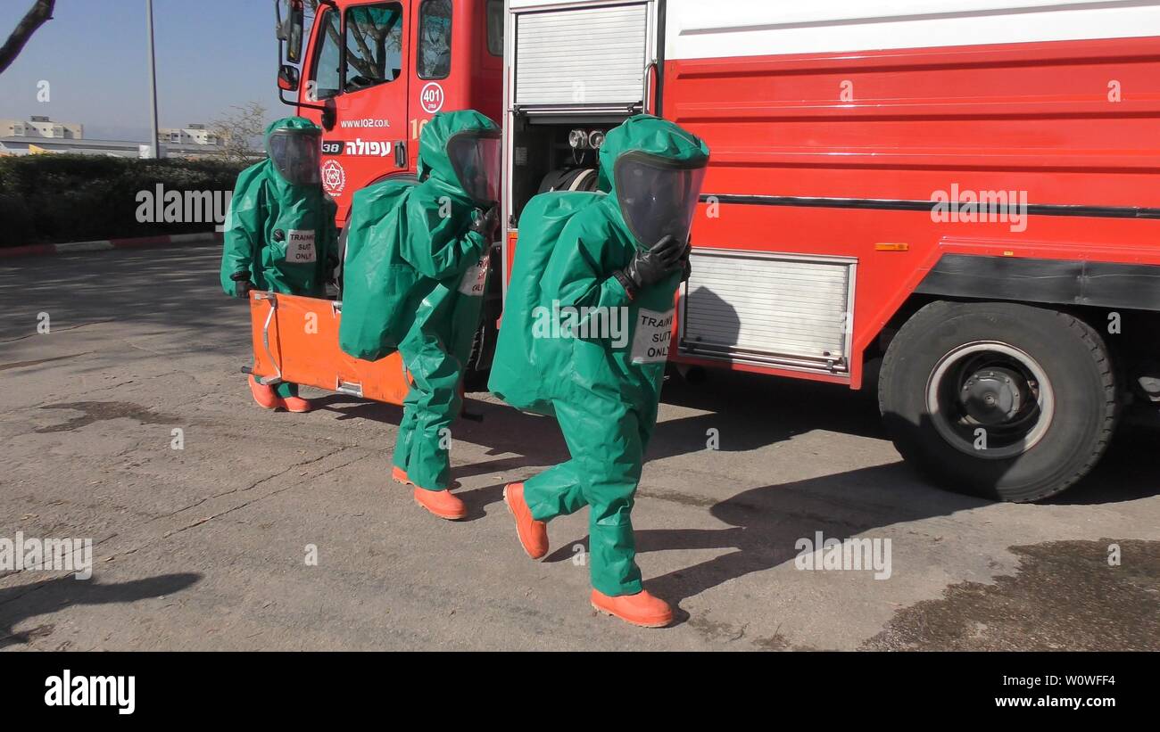 I vigili del fuoco di medicazione suite di protezione pronto per pulire le vittime da perdite tossici dei gas medicali in ospedale Haemek durante il trapano. Afula, Israele, 30 Gennaio 2017 Foto Stock