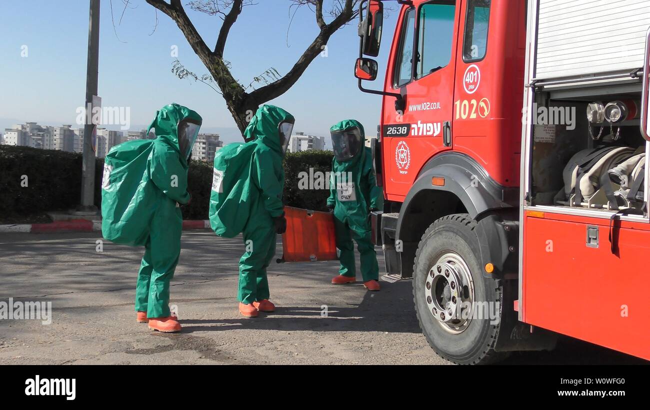 I vigili del fuoco di medicazione suite di protezione pronto per pulire le vittime da perdite tossici dei gas medicali in ospedale Haemek durante il trapano. Afula, Israele, 30 Gennaio 2017 Foto Stock