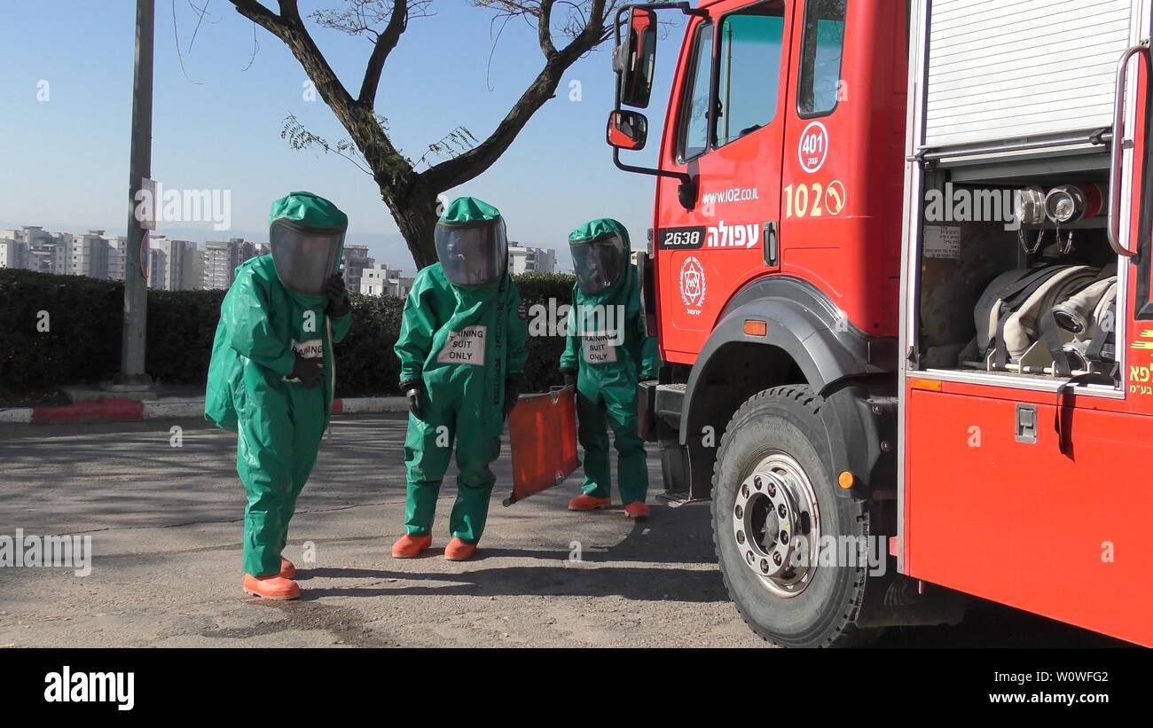 I vigili del fuoco di medicazione suite di protezione pronto per pulire le vittime da perdite tossici dei gas medicali in ospedale Haemek durante il trapano. Afula, Israele, 30 Gennaio 2017 Foto Stock