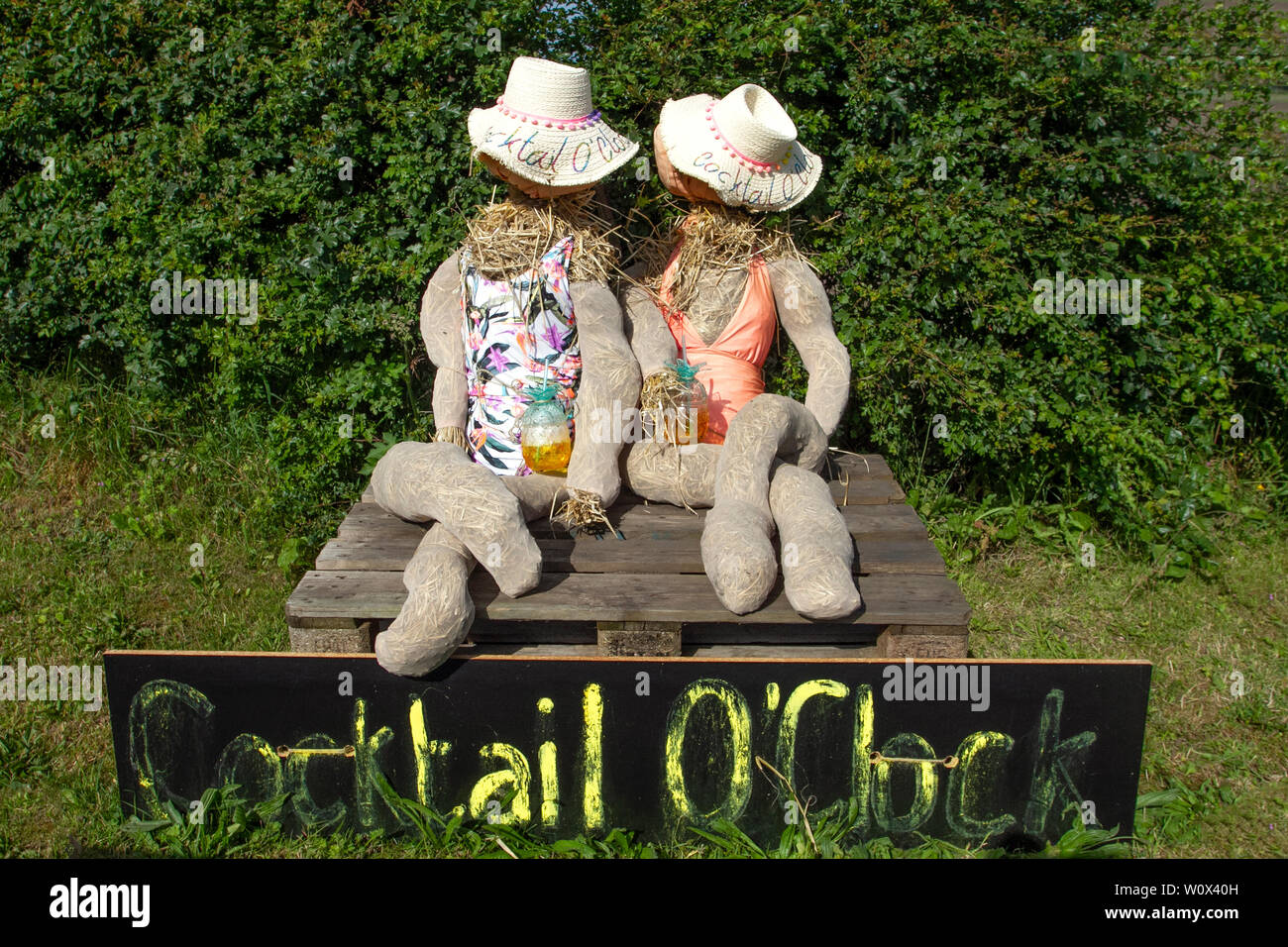 Manichino donna vestita in un colorato abiti estivi e un cappello di paglia  con un segno di vendita Foto stock - Alamy