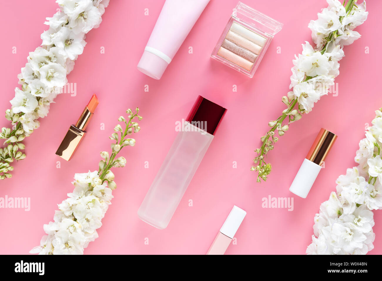 Cosmetici per il viso prodotti di bellezza con fiore bianco su rosa pastello sfondo desktop. bellezza naturale per la cura della pelle, layout vista superiore, piatto laici. Foto Stock