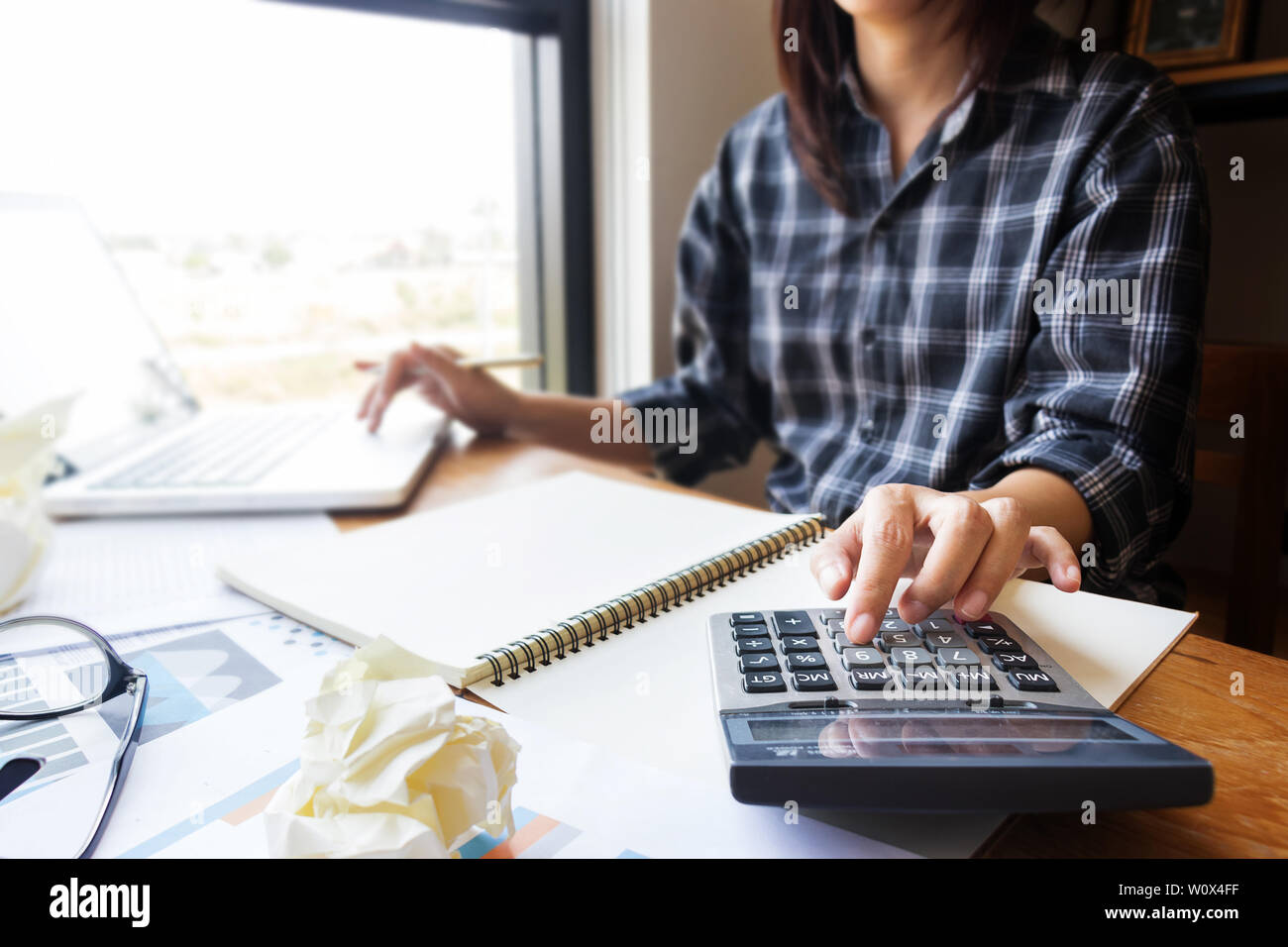 Business donna utilizzando la calcolatrice in ufficio per il calcolo delle informazioni contabili e finanziarie come ragioniere lavoro. chiudere fino al dito sulla calcolatrice Foto Stock
