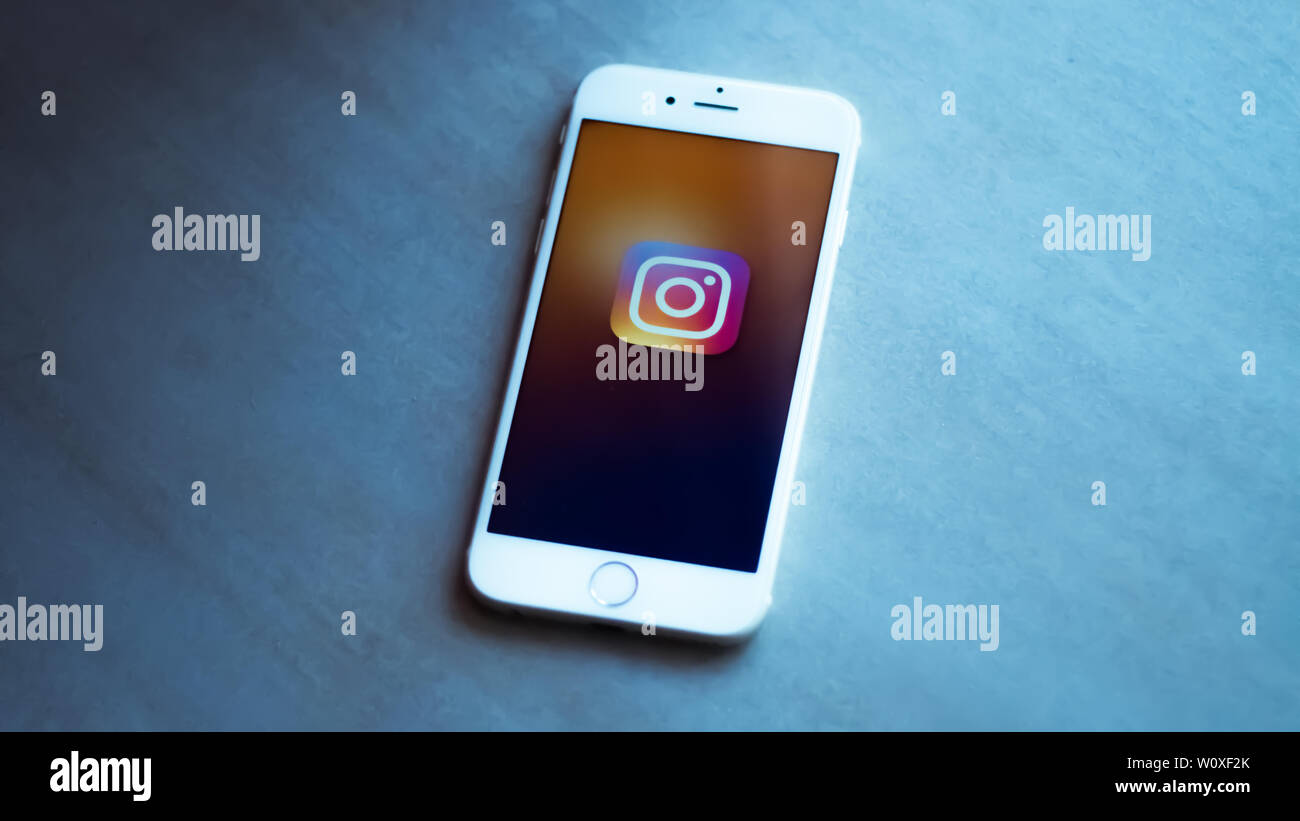 New York / Usa 06-27-2019: un bianco smartphone con l'icona della rete sociale instagram rappresentata è appoggiato su di una pietra grigia sullo sfondo. Foto Stock