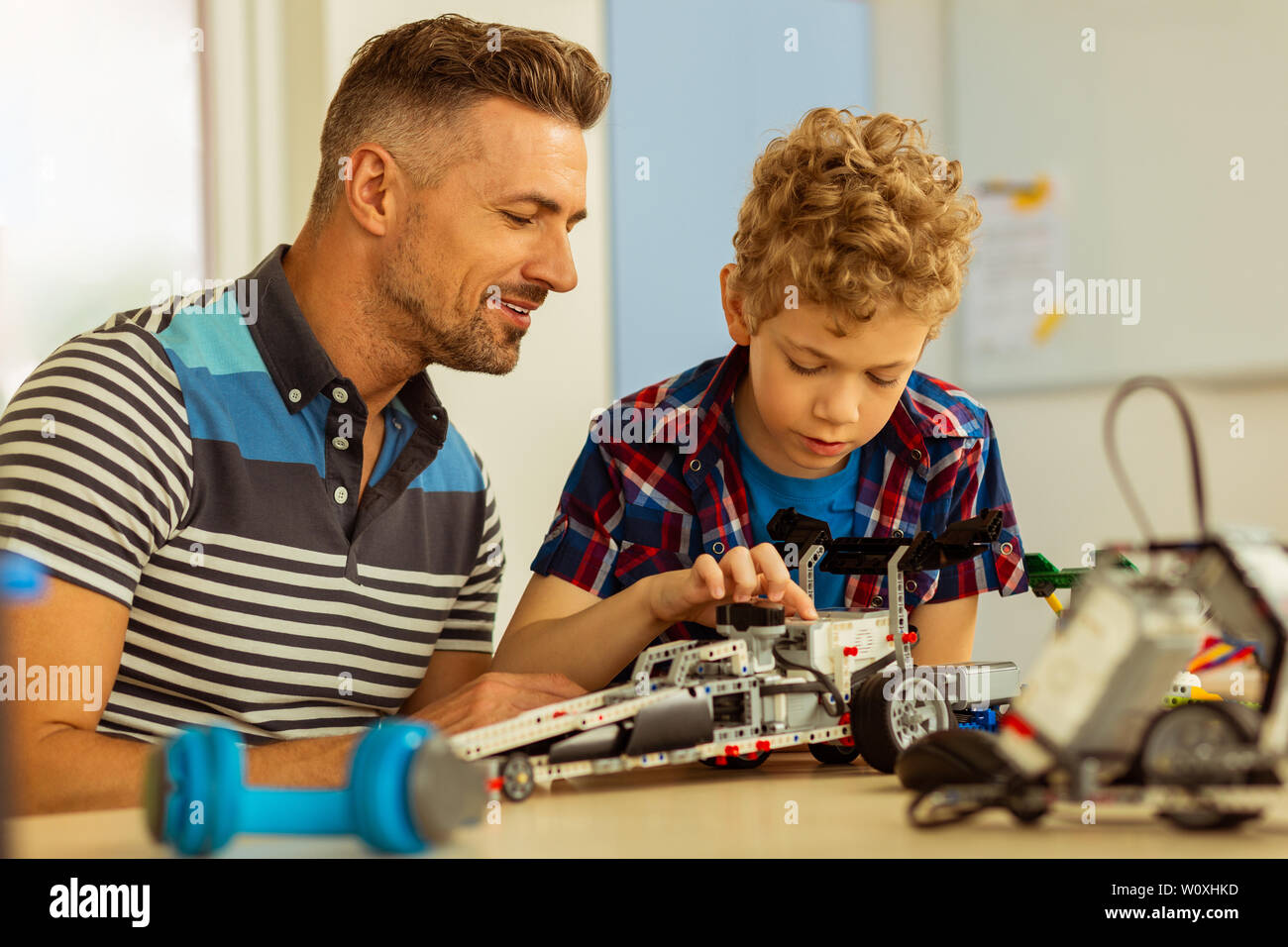 Interessi comuni. Piacevoli nice padre e figlio seduti insieme mentre avente lo stesso hobby Foto Stock