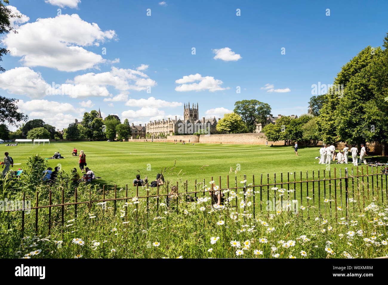 Un soleggiato luminosamente Merton College, inclusa la cappella tower, visti in tutta la Chiesa di Cristo Prato campi di gioco su una bella giornata estiva in Oxford. Foto Stock