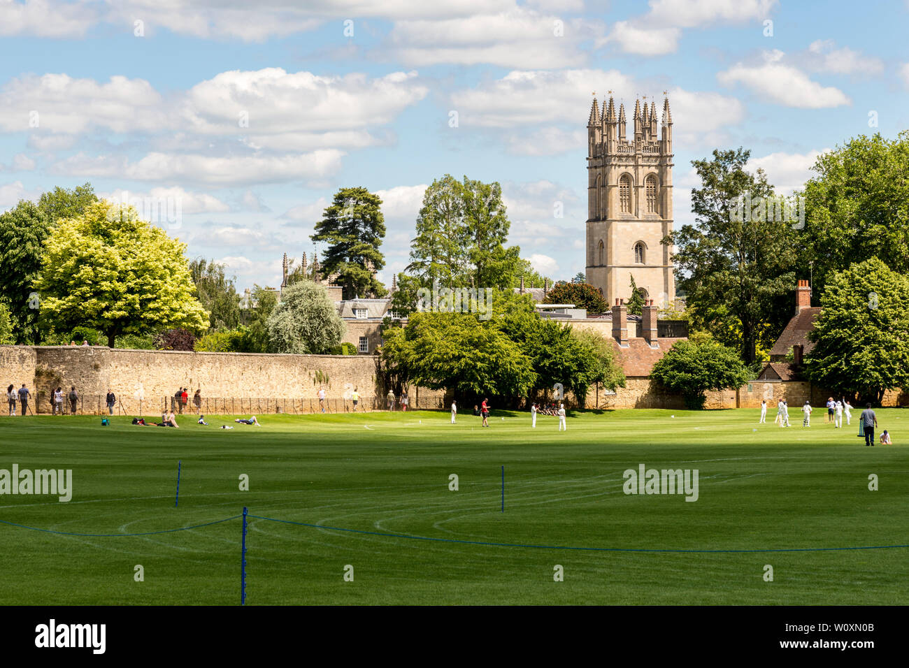 Soleggiato luminosamente Magdalen Tower si vede attraverso la Chiesa di Cristo i prati i campi da gioco in una bella giornata estiva nella famosa città universitaria di Oxford. Foto Stock