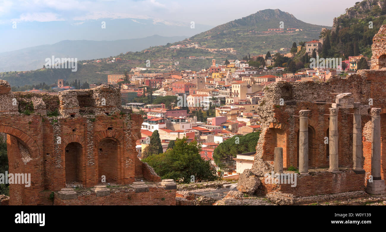 Vista panoramica di rovine dell antico teatro greco e il centro storico di Taormina in giornata soleggiata, Sicilia, Italia Foto Stock