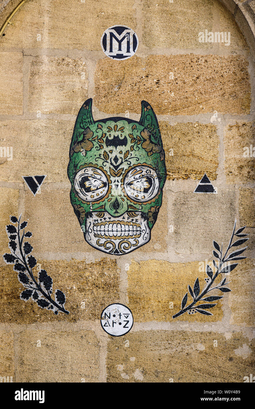 Illustrazione dettagliata su un muro di pietra a Bordeaux, Francia. Cranio stilizzata con maschera a forma di Batman da NotyAroz. Foto Stock