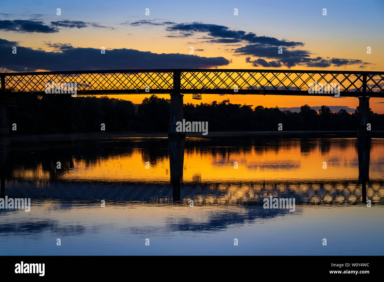 Il Gustave Eiffel progettato C19 ponte in ferro a Cadillac, oltre il Fiume Garonne, nel dipartimento Gironde, Francia. Il tramonto. Foto Stock