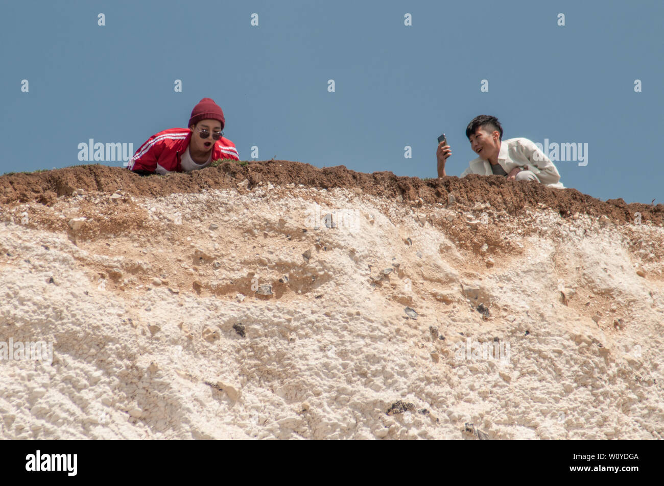 Birling Gap, Eastbourne, East Sussex. 28 Giugno 2019. UK Weather: Il glorioso clima estivo sta portando i turisti che si affollano nel punto di bellezza della costa meridionale. Alcuni sembrano ignari della fragilità e della sottoquotazione lungo le scogliere di gesso. Cadute di roccia che si verificano frequentemente. Non è sicuro sul bordo. Si prega di tenere al sicuro. . Foto Stock