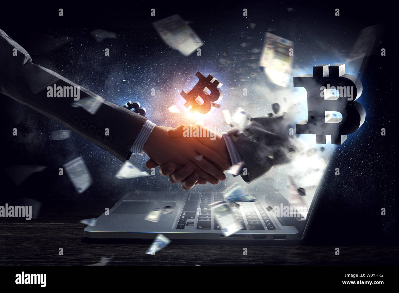 Handshake aziendale da parte di un uomo e di una donna, laptop e bitcoin simboli. I supporti misti Foto Stock