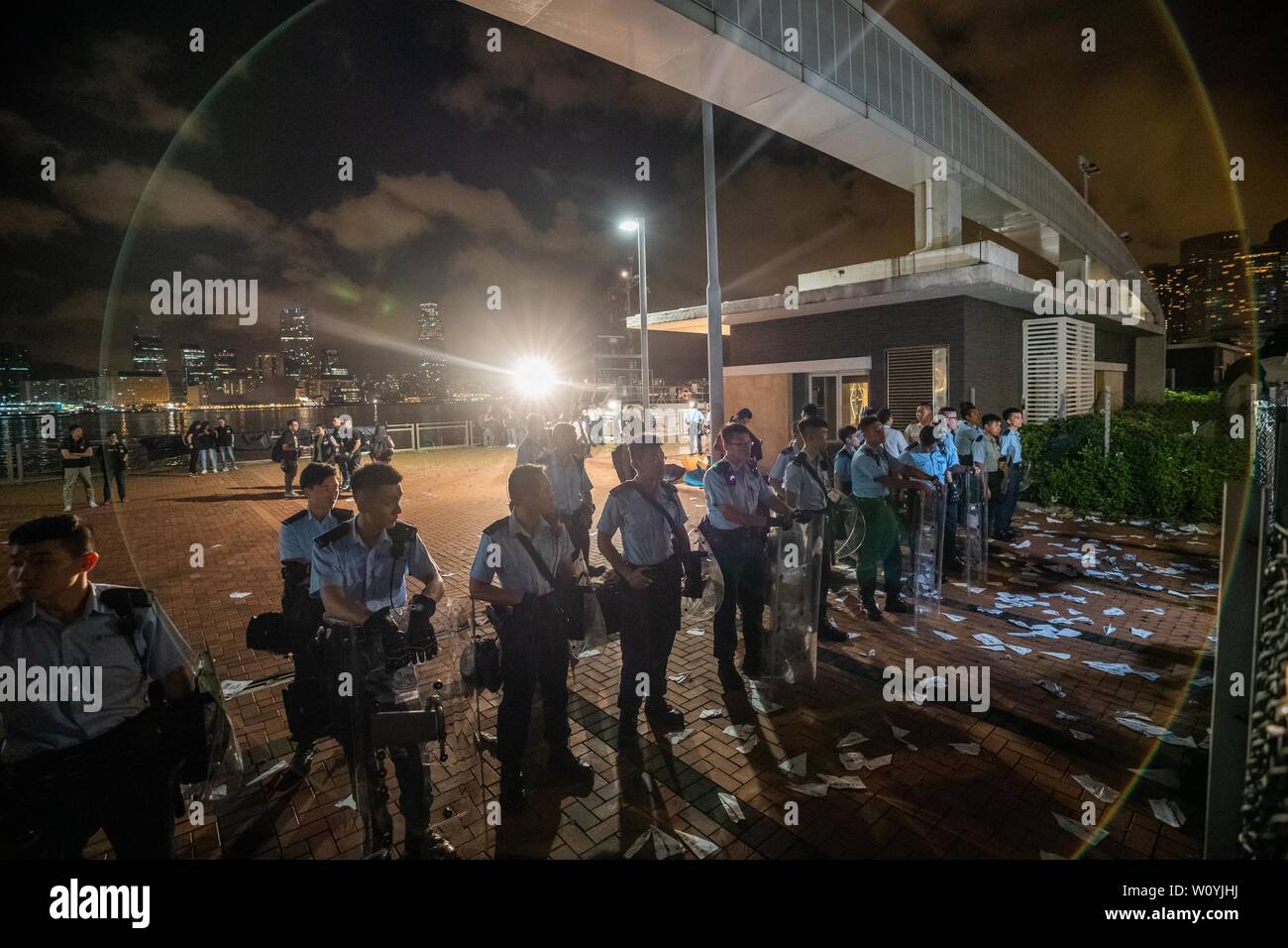 Gli ufficiali di polizia visto custodire l'appezzamento di terreno nel centro di Waterfront che per essere trasferiti ai cinesi Esercito del popolo. Centinaia di manifestanti rally contro il governo di trasferimento di un appezzamento di terreno sul lungomare centrale per il popolo cinese della Esercito di Liberazione (PLA) come un militare di dock. Pro-democrazia dimostranti di Hong Kong hanno organizzato manifestazioni nelle scorse settimane, per chiedere il ritiro di un controverso disegno di legge in materia di estradizione, le dimissioni del territorio è chief executive Carrie Lam, un'indagine polizia brutalità e goccia riot accuse contro manifestanti pacifici. Foto Stock