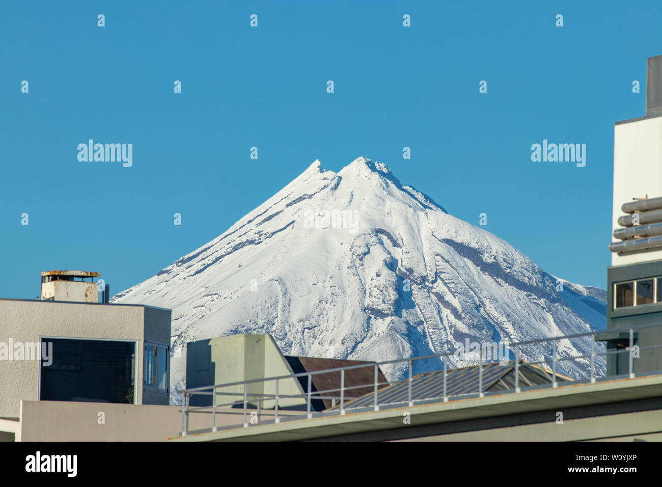 Mt Egmont incombente su nuovi edifici di Plymouth Foto Stock