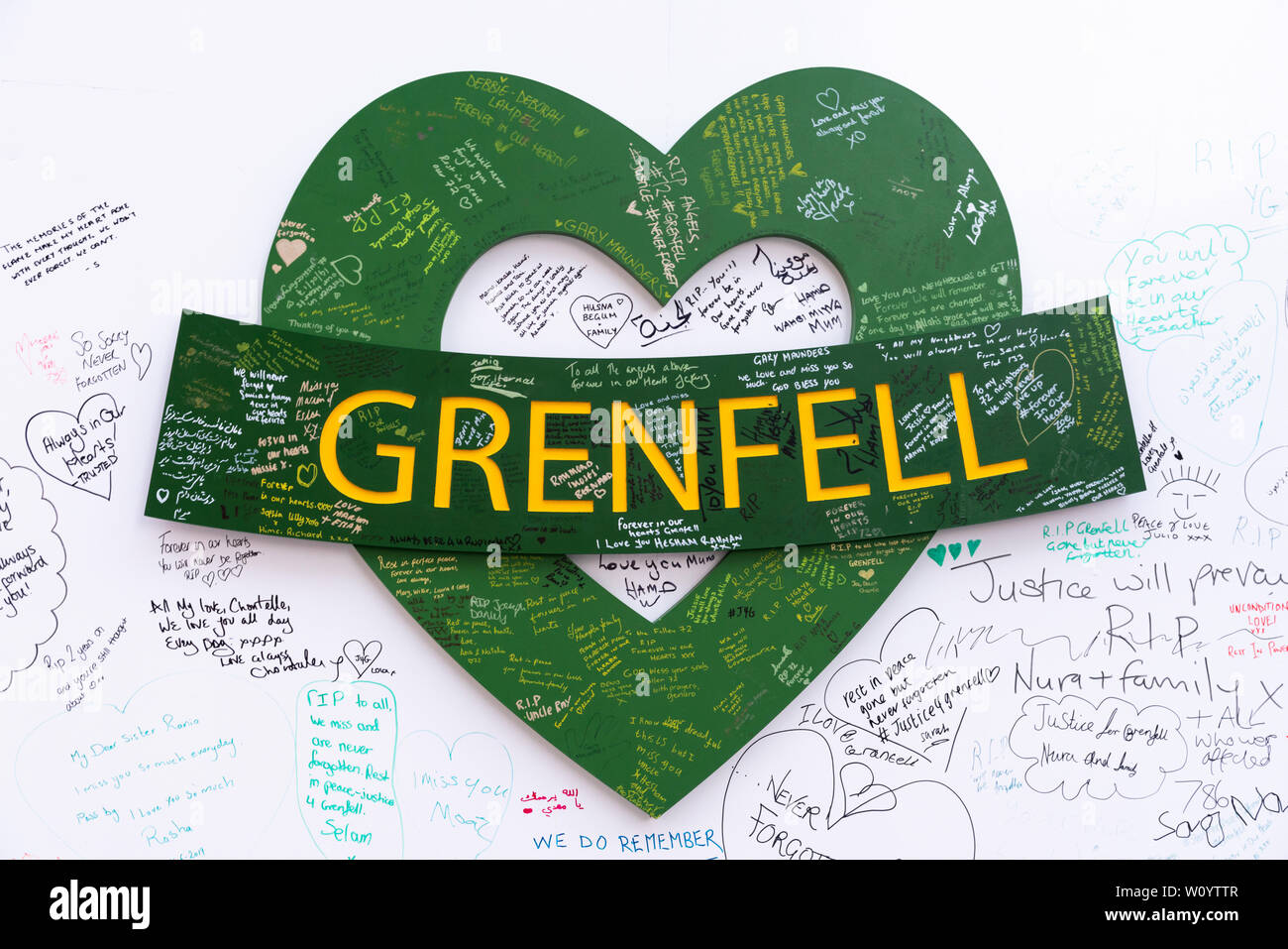 Opera d'arte con motivi a cuore verde sulla parete commemorativa della Grenfell Tower. Foto Stock