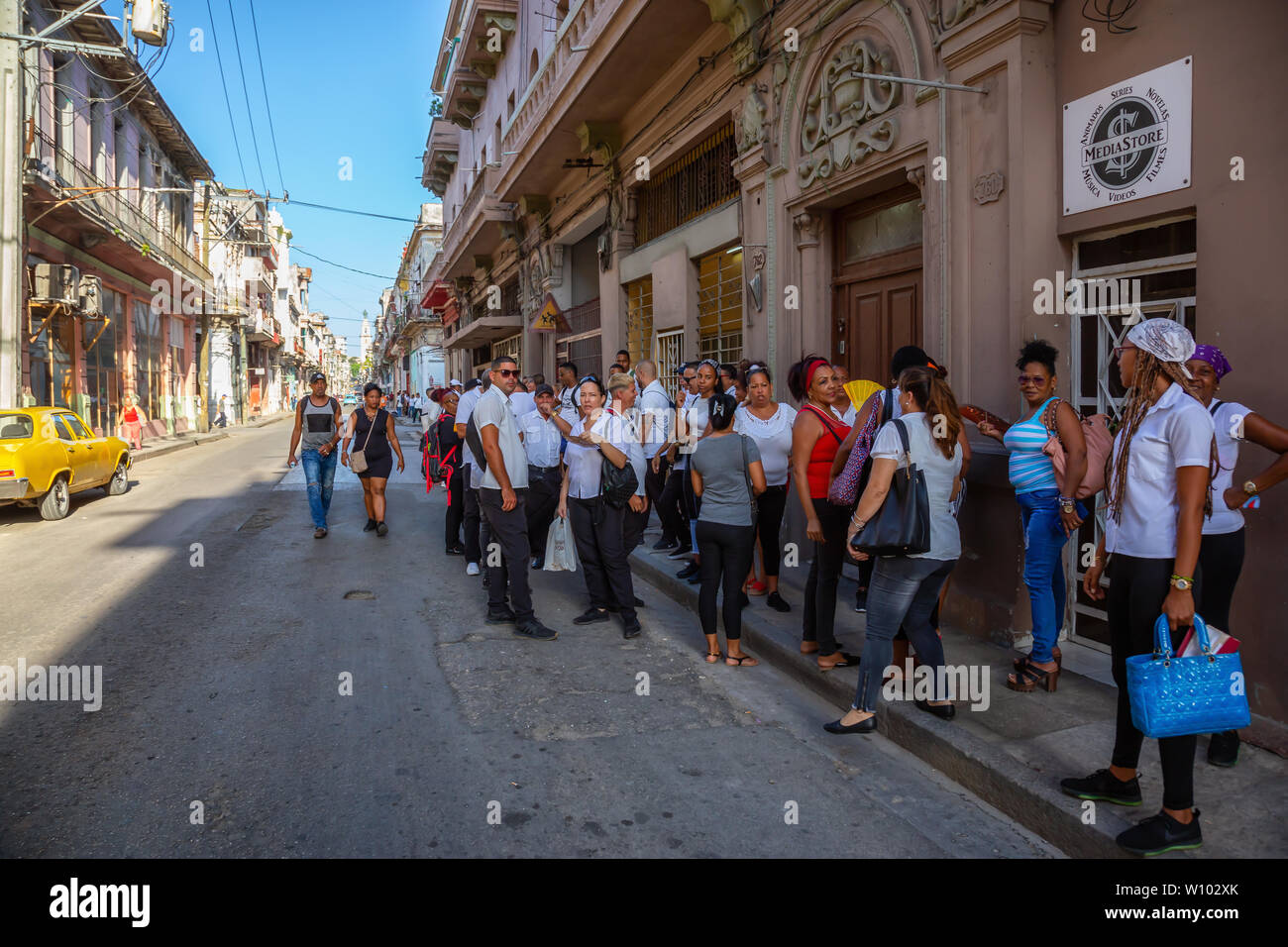 L'Avana, Cuba - 13 Maggio 2019: folla di popolo cubano in attesa in linea per il cibo nelle strade della vecchia Havana City durante una luminosa mattina di sole. Foto Stock