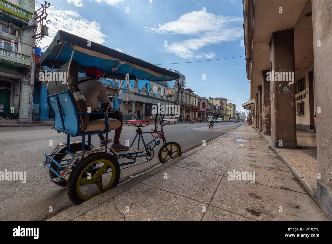 L'Avana, Cuba - 14 Maggio 2019: Noleggio Taxi Driver in bici per le strade di l'Avana Vecchia Città durante un vivace e luminosa mattina di sole. Foto Stock