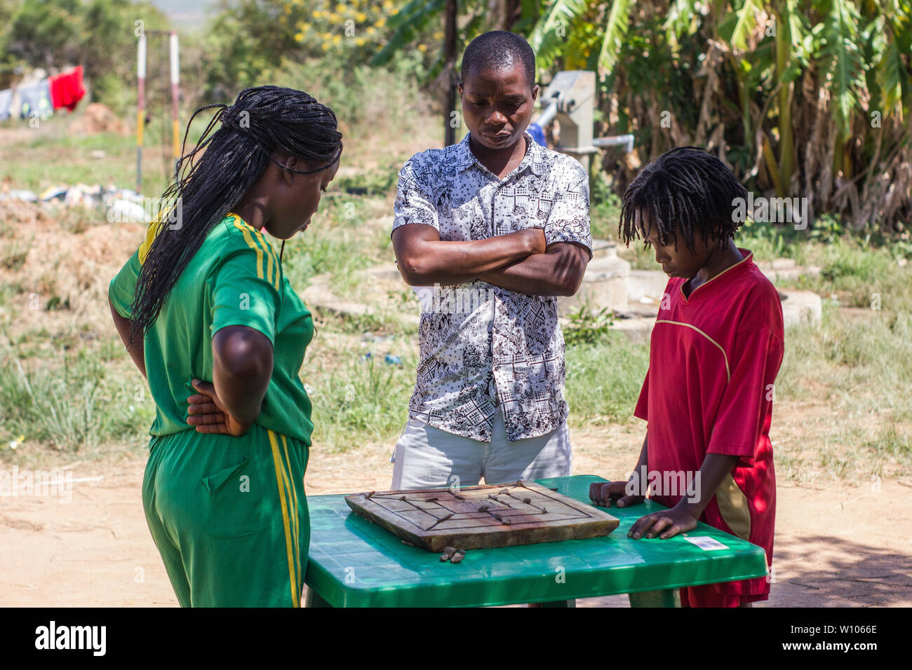Tradizionale strategia africana board game sapere come morabaraba o muravarava essendo giocato su una tavola di legno con tappo di bottiglia pezzi Foto Stock