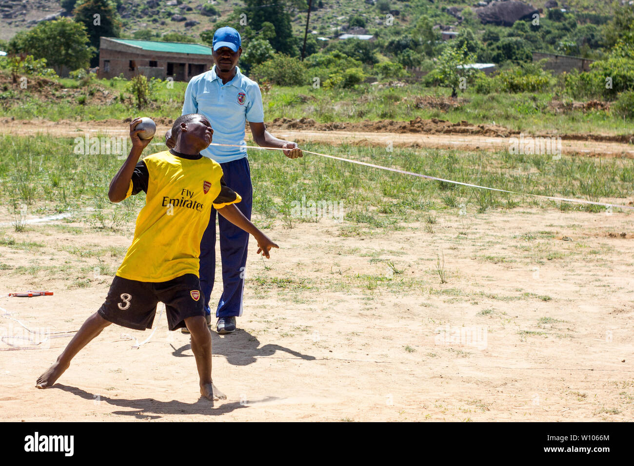 Allievo che lancia una sfera nella categoria shot put nella loro classe di educazione fisica Foto Stock