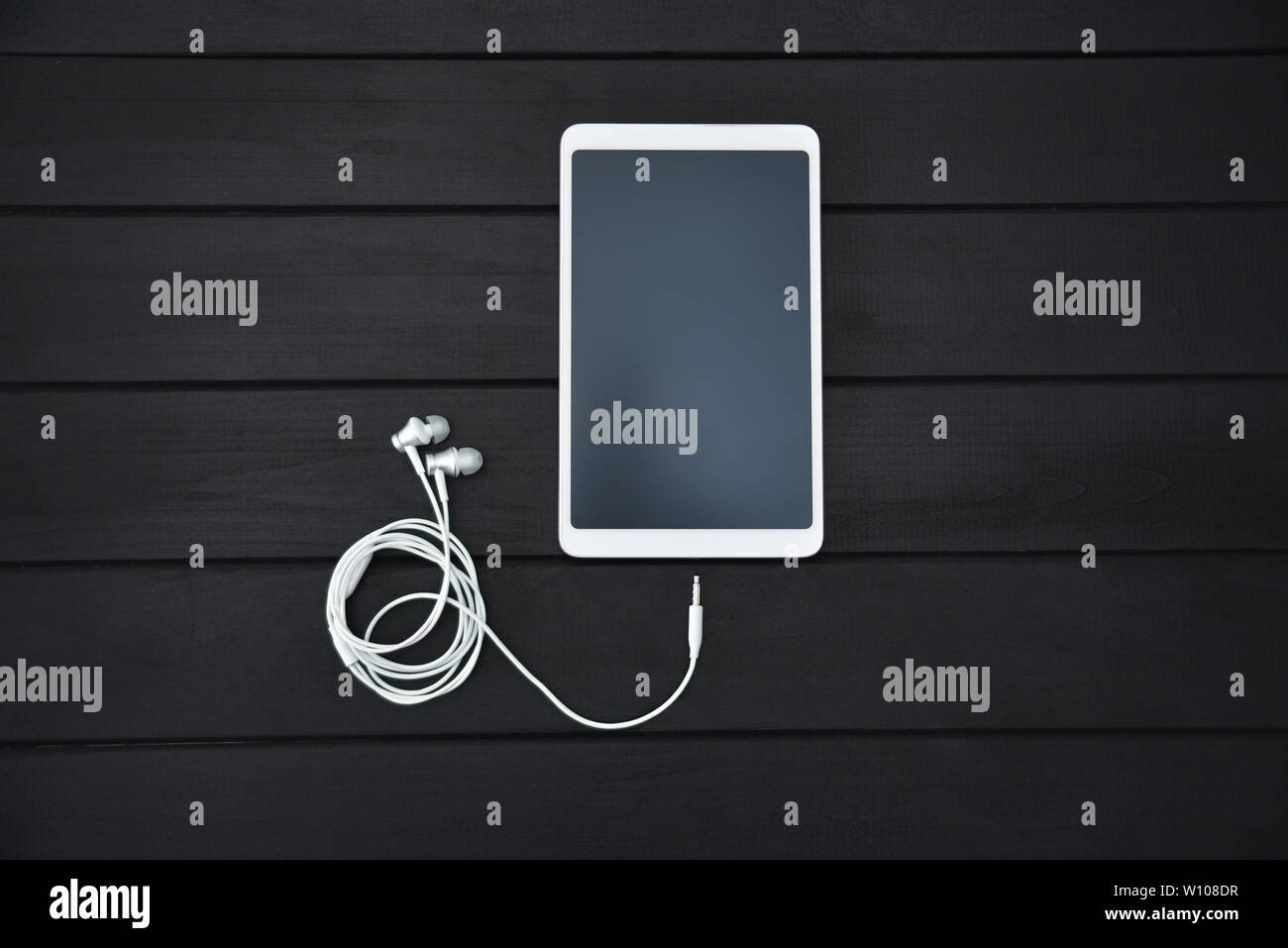 Tecnologia, musica, gadget e la nozione di oggetto - close up white smartphone , tablet pc e auricolari su sfondo di legno Foto Stock
