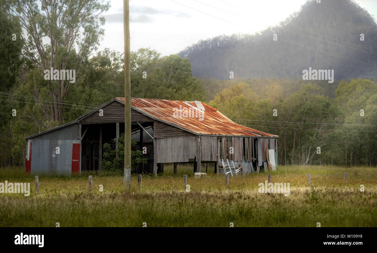 Vecchia fattoria sparso nel tardo pomeriggio con un raggio di trasmissione della luce attraverso la nebbia Foto Stock