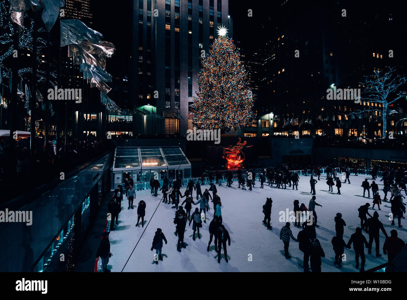 Albero di natale e la pista di pattinaggio su ghiaccio al Rockefeller Center di notte in Midtown Manhattan, a New York City Foto Stock