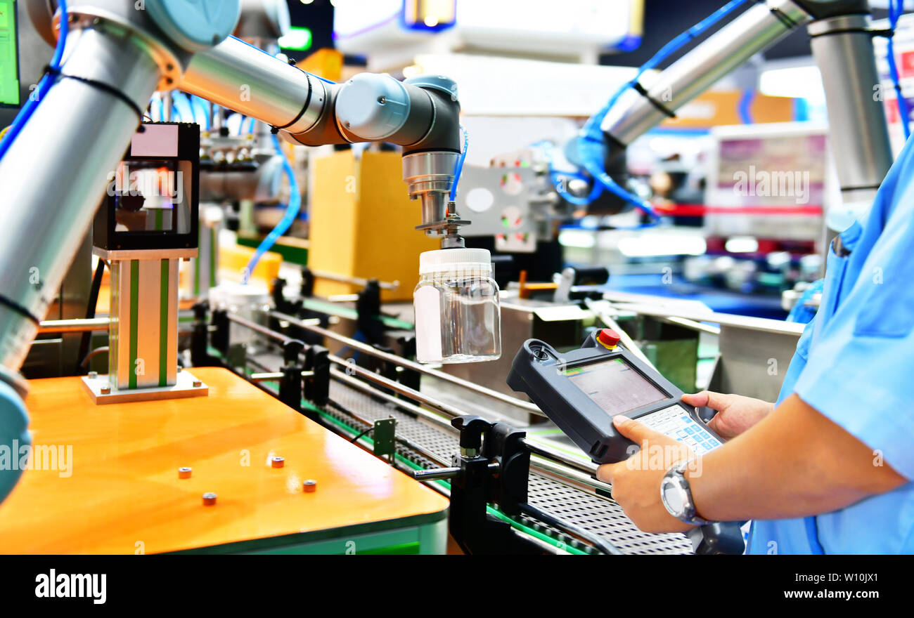 Controllo tecnico e automazione di controllo robot bracci disposti bicchiere di acqua in bottiglia in automatico dei macchinari industriali apparecchiature in linea di produzione di fabbrica Foto Stock