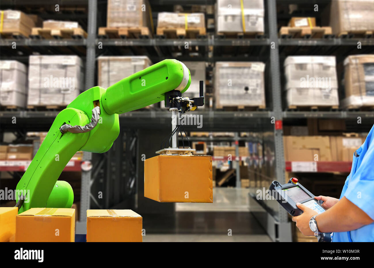 Robot industriale tenendo un casella di lavoratore e di funzionamento di una macchina di robot con un pannello di controllo sul magazzino ripiani sfondo Foto Stock