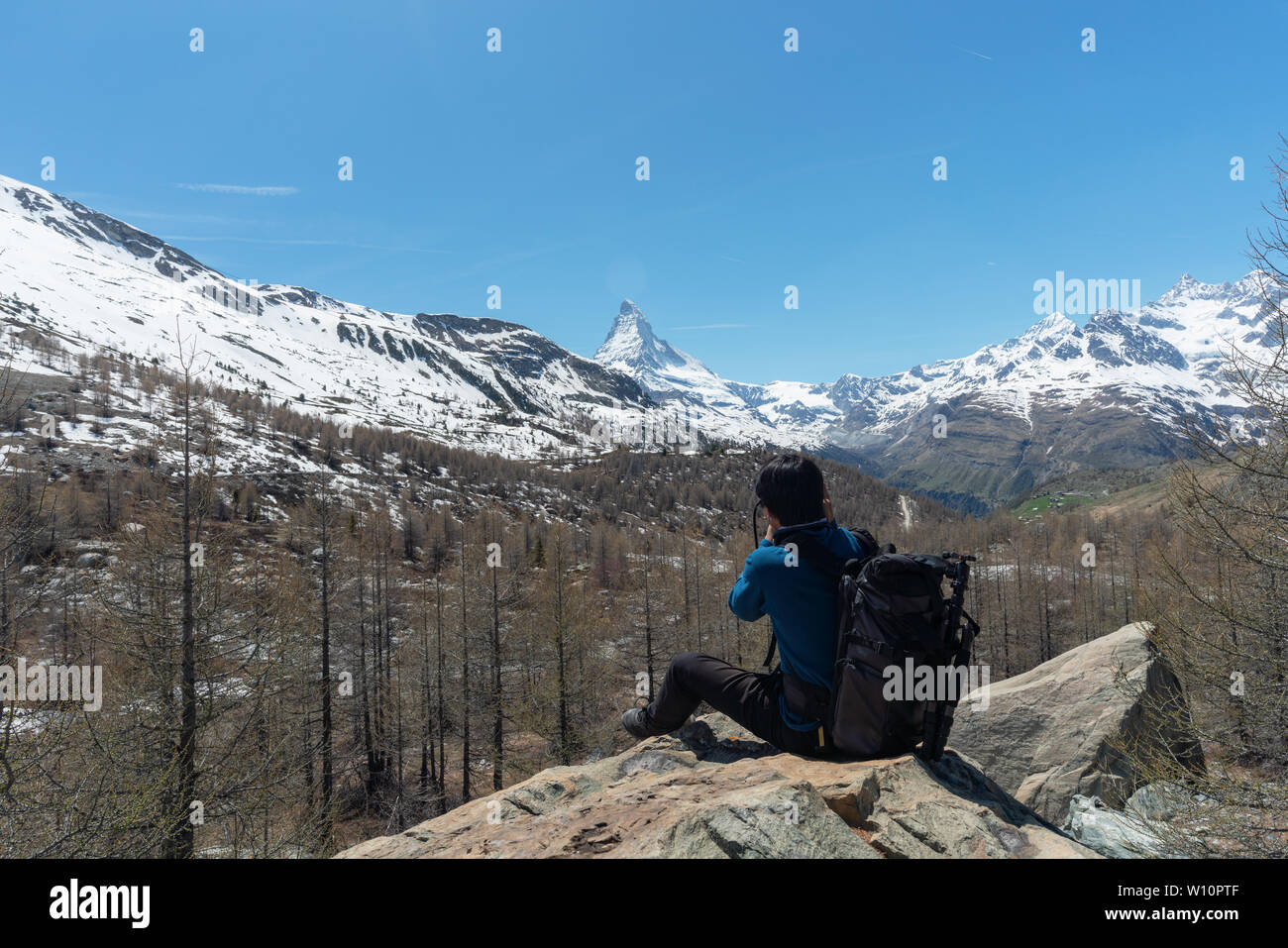 Viaggiare in Svizzera, un uomo con uno zaino prendendo fotografia di monte Cervino, Alpi mountain range. Trekking in Zermatt, Svizzera Foto Stock
