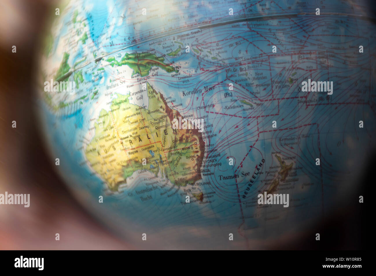 Globo del mondo con la messa a fuoco e di evidenziare in Australia. I nomi dei luoghi sono in tedesco. Lo sfondo ha una leggera sfocatura di movimento. un grafico di viaggio Foto Stock