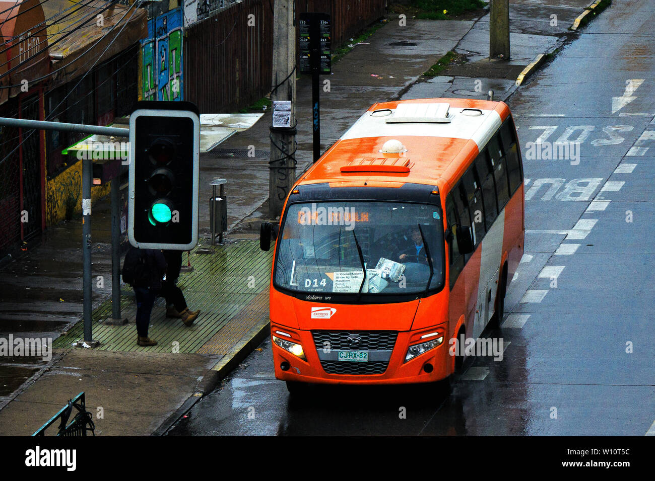 SANTIAGO DEL CILE - Maggio 2016: una piccola arancia Transantiago bus durante un giorno di pioggia Foto Stock