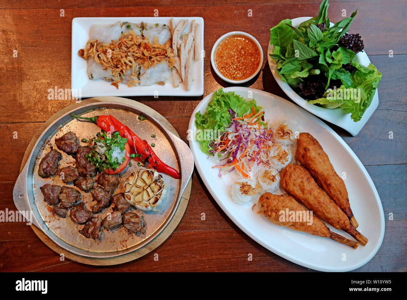 Vista dall'alto di popolari piatti vietnamiti sul tavolo di legno Foto Stock