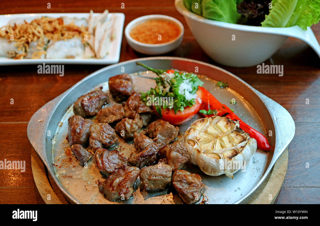 Bistecca di manzo con verdure alla griglia servita su sfrigolanti caldo piastra di ferro Foto Stock
