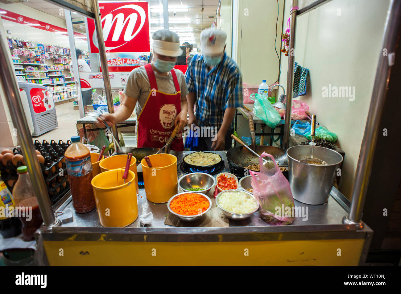 Cibo di strada facendo di stallo crepes sul fronte fiume di Vientiane, Laos. La città è un ex colonia francese. Foto Stock