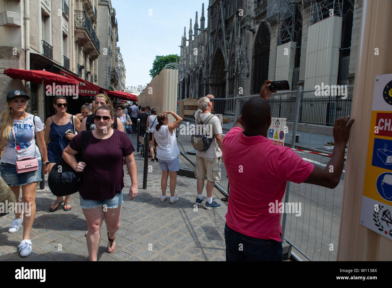I turisti vicino alla cattedrale di Notre Dame dopo l'incendio che ha devastato, Paris, Francia. Foto Stock