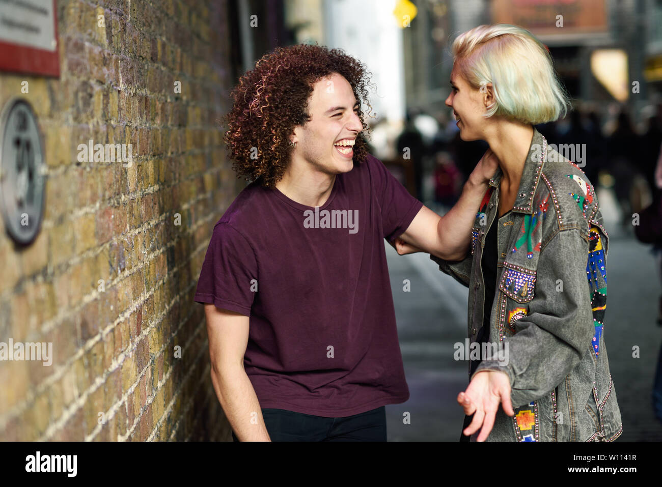 Coppia giovane parlando in background urbano su una tipica strada di Londra. Foto Stock