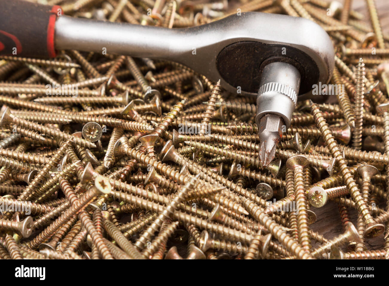 Cacciavite giacente su un mucchio di viti. L'attrezzo e attrezzature Foto Stock