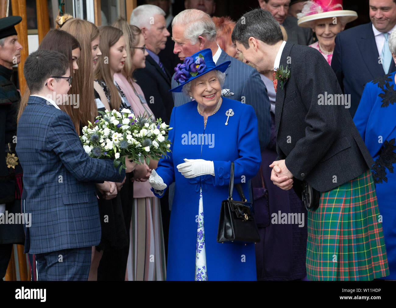 La regina Elisabetta II, accompagnata da Ken Macintosh (destra), presiedere Officer del parlamento scozzese, incontra i membri del giovane Scozzese presso il parlamento scozzese di Edimburgo durante una cerimonia che segna il ventesimo anniversario della deconcentrazione. Foto Stock