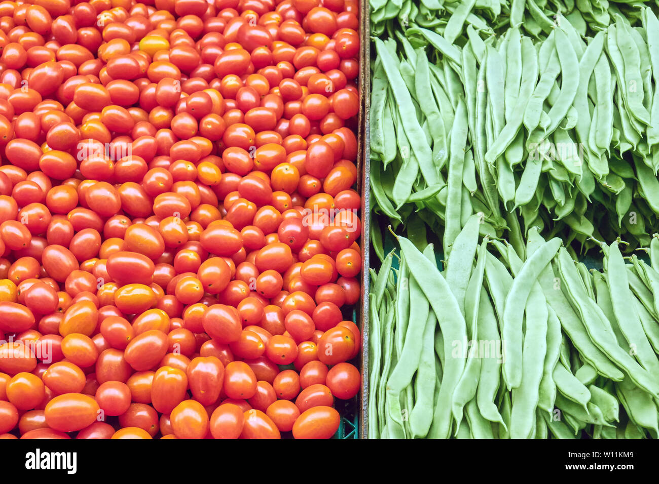 Piccoli pomodori e fagioli verdi per la vendita su un mercato Foto Stock
