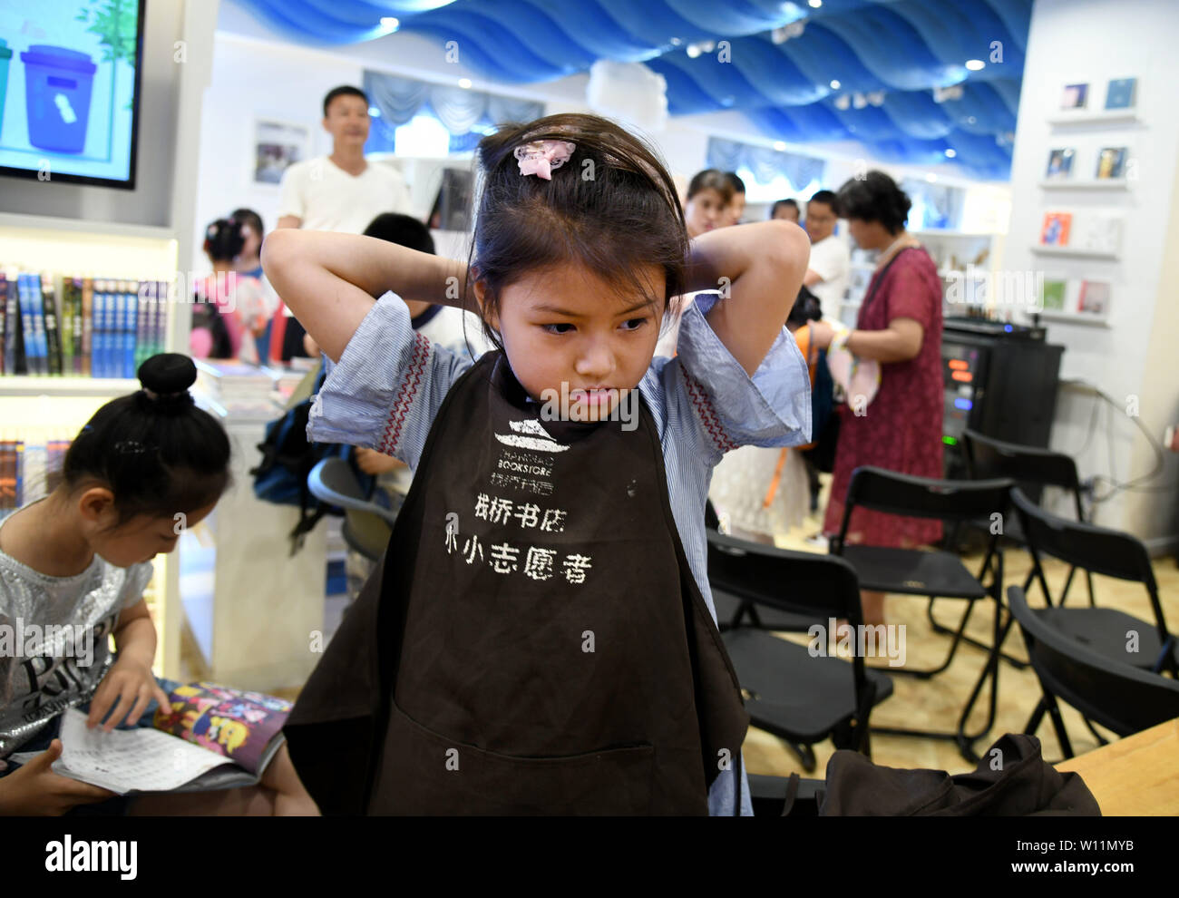 (190629) -- QINGDAO, Giugno 29, 2019 (Xinhua) -- un giovane volontario è pronta per lavorare a Zhanqiao Bookstore di Qingdao, est della Cina di Shandong, Giugno 29, 2019. Più di trenta ragazzi erano addestrati come volontari in Zhanqiao Bookstore. Durante le vacanze estive, essi saranno impegnati in lettori di orientamento, libri di ordinamento, il benessere pubblico attività e altri lavori all'interno delle loro capacità. In ritorno, sono concesse priorità nel prendere i libri in prestito, con qualche dato a loro come doni. (Xinhua/Li Ziheng) Foto Stock
