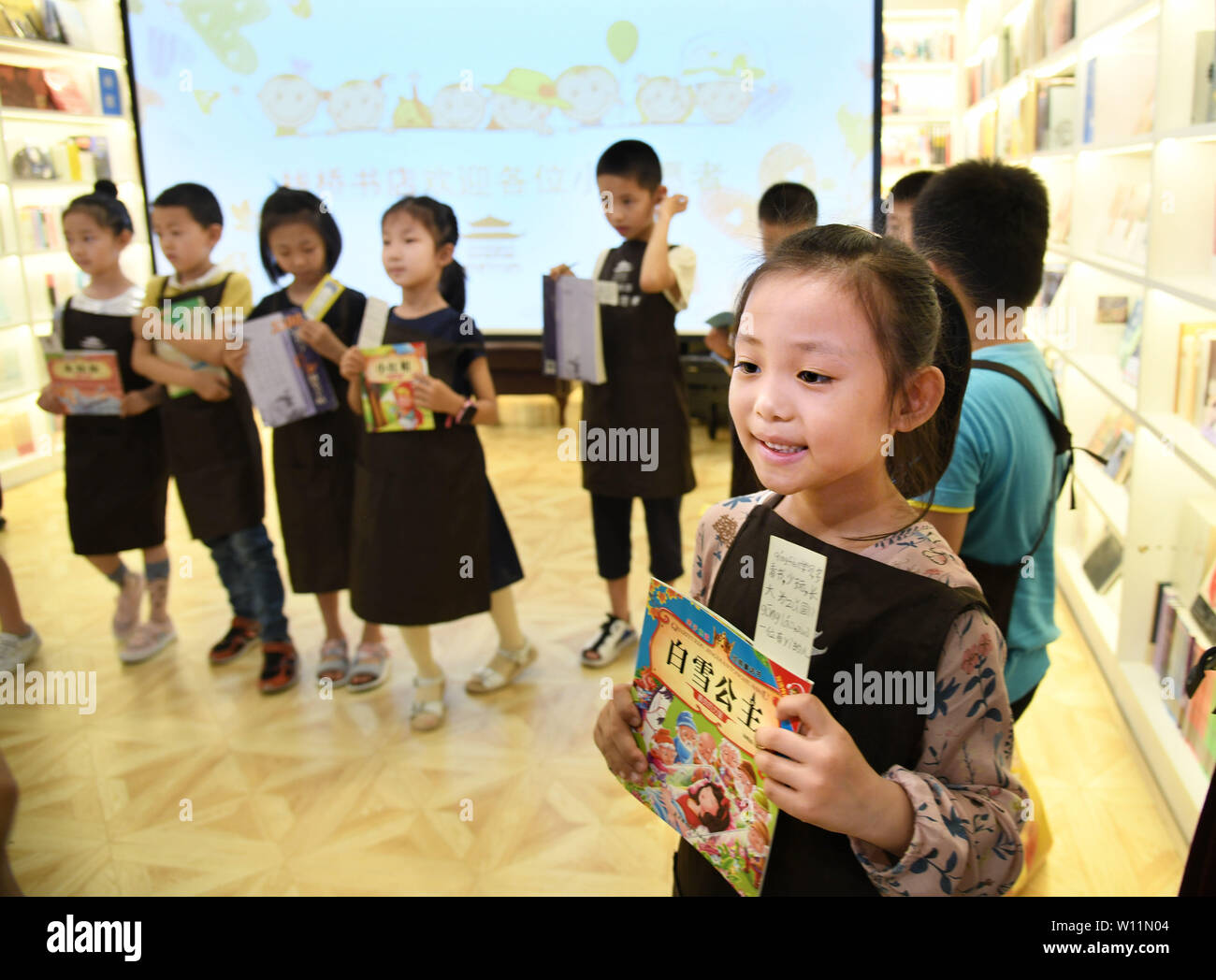 (190629) -- QINGDAO, Giugno 29, 2019 (Xinhua) -- i giovani volontari selezionare i libri per ragazzi che vivono in remoti indigenza zone montuose ad Zhanqiao Bookstore di Qingdao, est della Cina di Shandong, Giugno 29, 2019. Più di trenta ragazzi erano addestrati come volontari in Zhanqiao Bookstore. Durante le vacanze estive, essi saranno impegnati in lettori di orientamento, libri di ordinamento, il benessere pubblico attività e altri lavori all'interno delle loro capacità. In ritorno, sono concesse priorità nel prendere i libri in prestito, con qualche dato a loro come doni. (Xinhua/Li Ziheng) Foto Stock