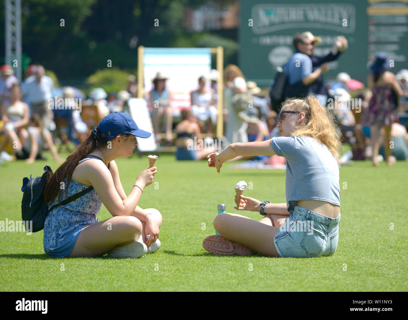 Due ragazze mangiare gelato, Devonshire Park, Eastbourne, Regno Unito. Il 29 giugno, 2019. Il tempo era perfetto per guardare il tennis, anche se forse è un po' calde da giocare - a valle di natura internazionali di tennis Foto Stock